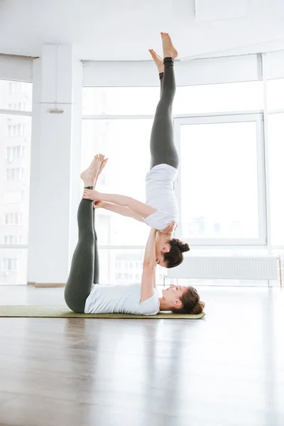 Twee schattige jonge vrouwen beoefenen acro yoga oefeningen — Stockfoto