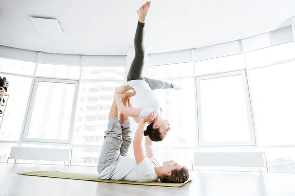 Rilassato giovane coppia bilanciamento e fare acro yoga — Foto Stock