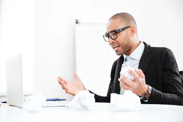 Chockad affärsman tittar på laptop i office — Stockfoto