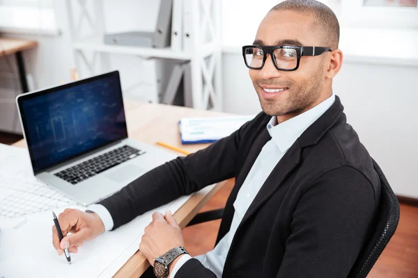 Young businessman sitting in the office and looking at camera — Stock Photo, Image