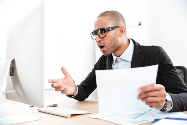 Businessman using a laptop and looking shocked — Stock Photo, Image