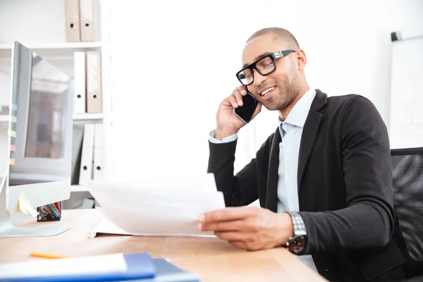 Trabajador de oficina llamando por teléfono y leyendo el documento de negocios —  Fotos de Stock