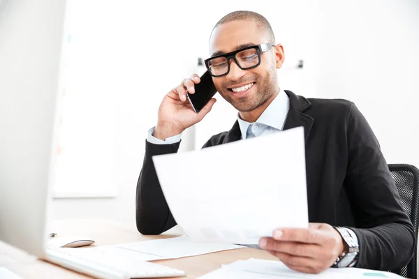 Empresario usando teléfono móvil y mirando documentos — Foto de Stock