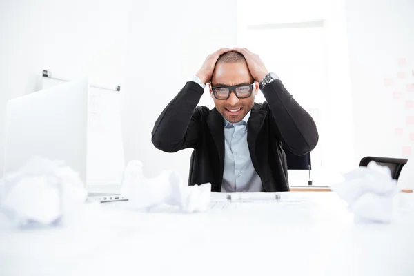 Empresario sobrecargado trabajando en computadora portátil y con dolor de cabeza —  Fotos de Stock