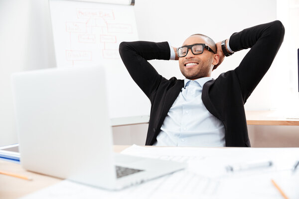 Businessman sitting back in his chair relaxing