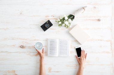 Akıllı telefon ve su bardağı tutan eller