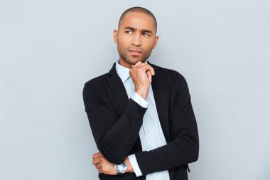 Yakışıklı dalgın adam gri arka plan üzerinde ayakta