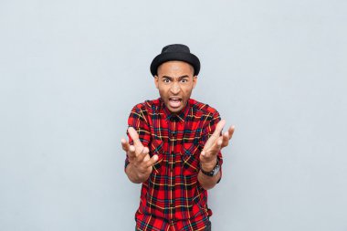 Kızgın kızgın Afrika adam ayakta ve bağırarak ekose gömlekli