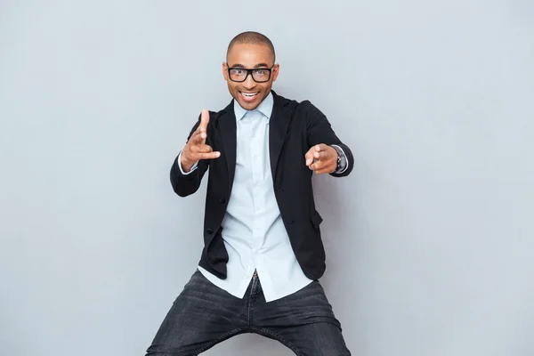 Young handsome man dancing over gray background — Stock Photo, Image