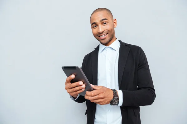 Χαρούμενος νεαρός επιχειρηματίας κρατάτε και χρησιμοποιείτε tablet — Φωτογραφία Αρχείου