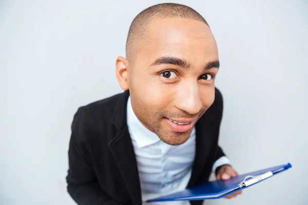 Smiling amusing african american young man holding clipboard — Stock Photo, Image