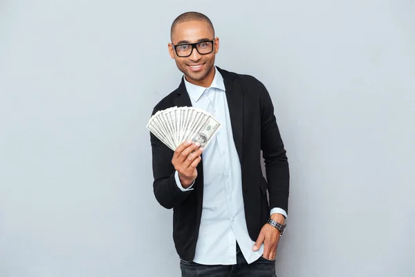 Alegre joven afroamericano de pie y sosteniendo el dinero — Foto de Stock