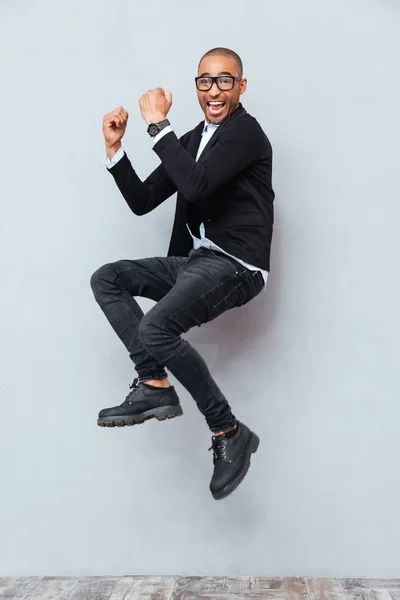 Feliz joven afroamericano emocionado saltando y celebrando el éxito — Foto de Stock