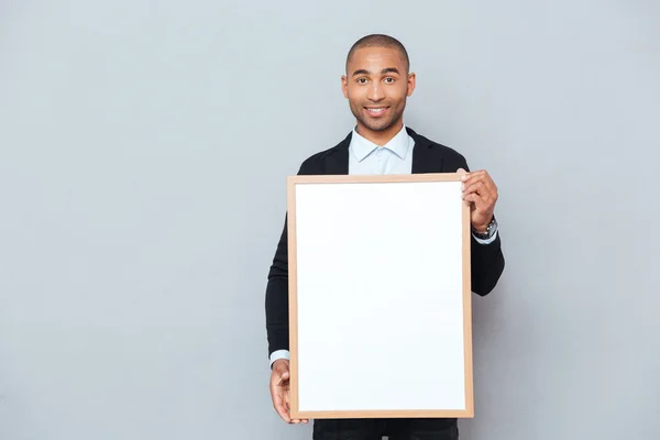 Glada attraktiv afrikanska man står och håller whiteboard — Stockfoto