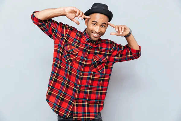 Smiling african young man standing and pointing on his head — Stock Photo, Image