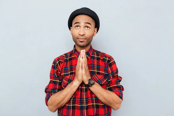 Bonito homem afro-americano de chapéu preto em pé e rezando — Fotografia de Stock