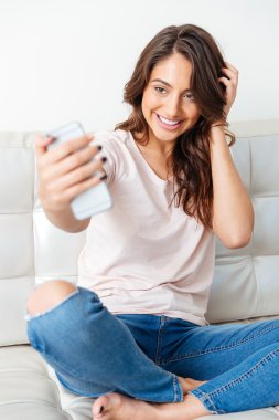 Selfie akıllı telefon ile beyaz arka plan üzerinde alarak çekici kız