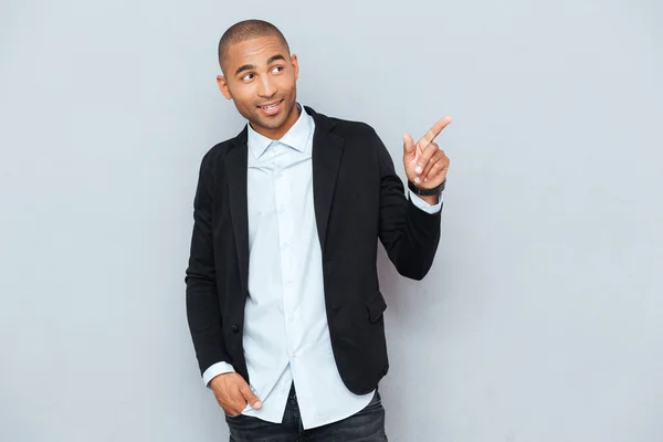 Retrato de um jovem feliz apontando para algo — Fotografia de Stock