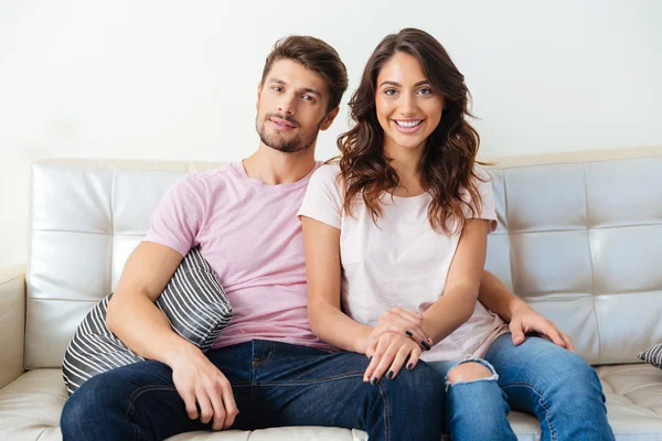 Feliz pareja sonriente sentada en el sofá sobre fondo blanco —  Fotos de Stock