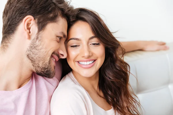 Close-up portrait of a beautiful smiling couple on couch — Stock Photo, Image