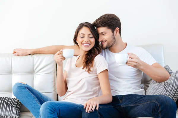 Retrato de una feliz pareja en el sofá tomando café —  Fotos de Stock
