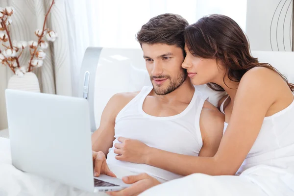 Hermosa pareja joven mirando portátil — Foto de Stock