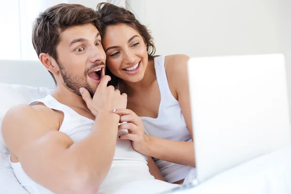 Счастливая молодая пара смеётся над чем-то в интернете — стоковое фото