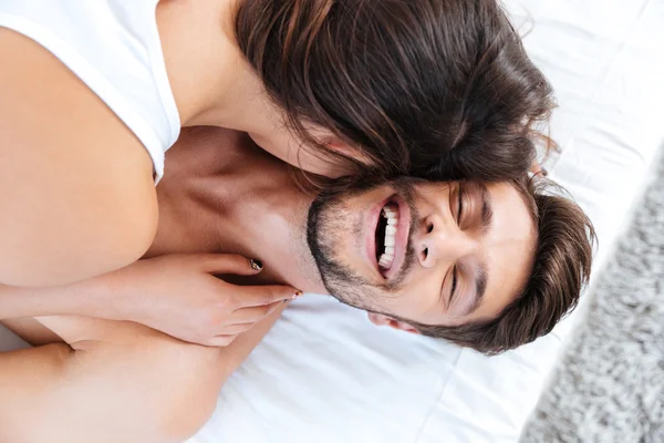 Close-up portrait of a young laughing couple in bed — Stock Photo, Image