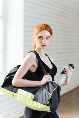 Şişe su ve spor çanta olan kadın