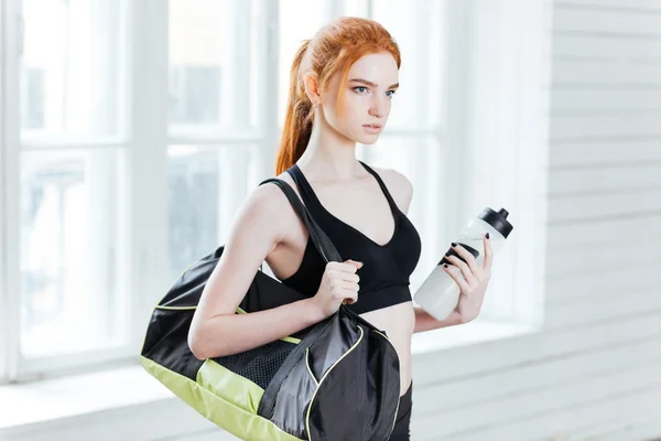 Jonge mooie fitness vrouw met sporttas en waterfles — Stockfoto