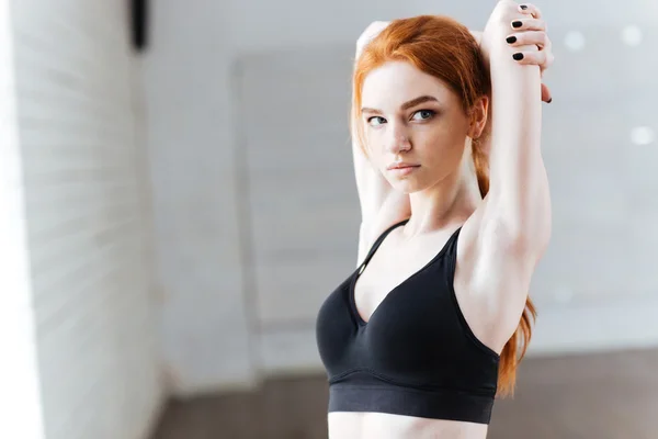 Close-up portrait of a beautiful young fitness woman streching