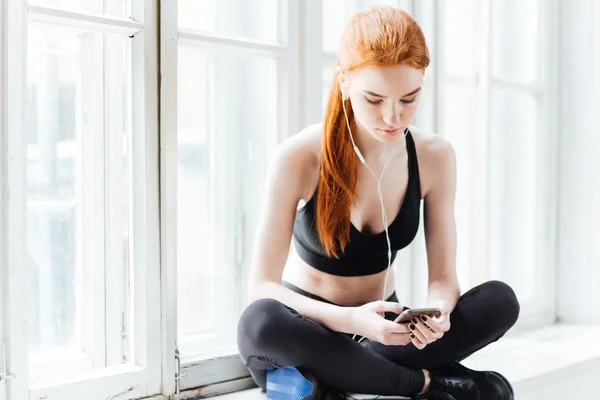 Retrato de cerca de una joven fitness con smartphone —  Fotos de Stock