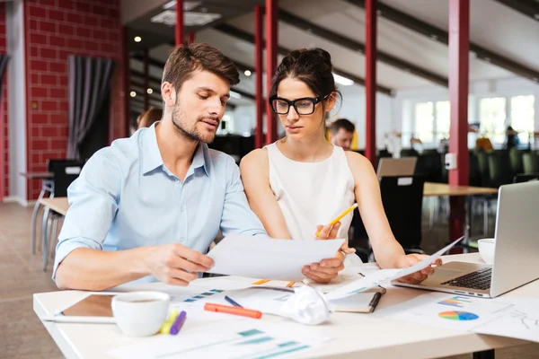 Serious young business man and woman working together in office — Stock Photo, Image