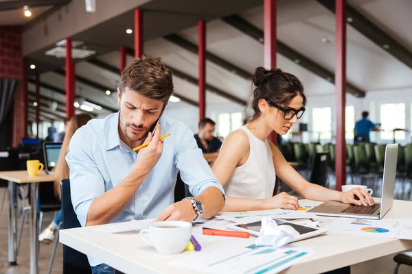 Jeune homme d'affaires et femme d'affaires concentrés travaillant dans le bureau — Photo