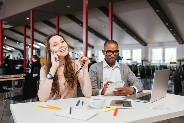 Glimlachend jonge zakenvrouw praten op mobiele telefoon in kantoor — Stockfoto