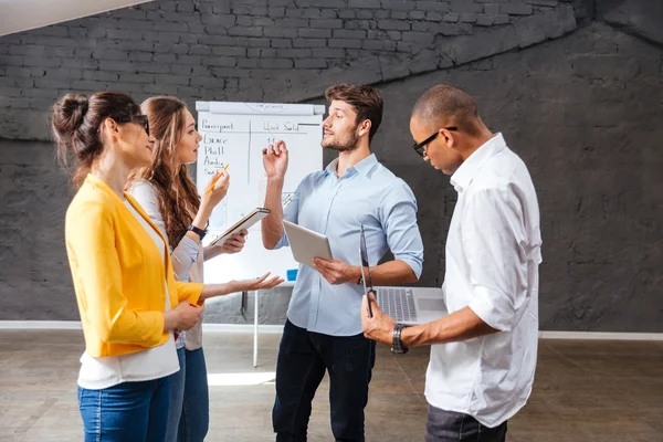 Multiethnische Gruppe von Menschen, die im Konferenzraum stehen und Brainstorming betreiben — Stockfoto