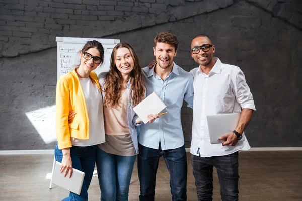 Multiethnic group of happy young business people standing in office — Stock Photo, Image