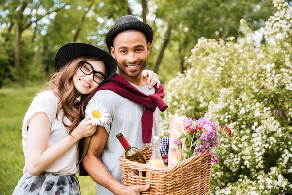 Couple joyeux avec de la nourriture et des boissons pour pique-nique dans le parc — Photo