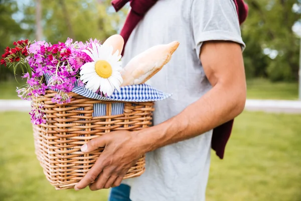 Fechar a cesta com comida e flores para piquenique — Fotografia de Stock