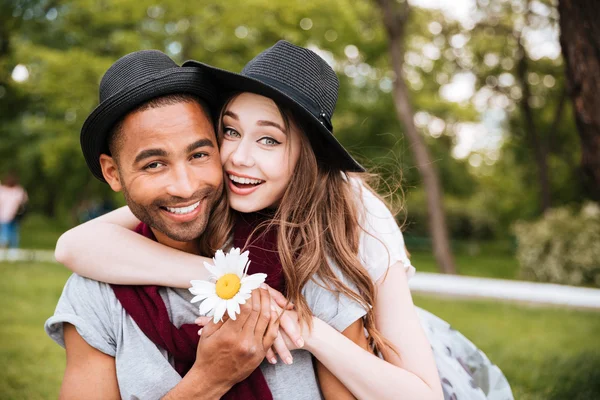 Fröhliches junges Paar umarmt und lächelt im Park — Stockfoto