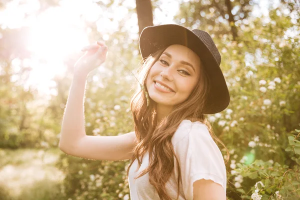 Fröhliche süße junge Frau mit Hut im Freien — Stockfoto