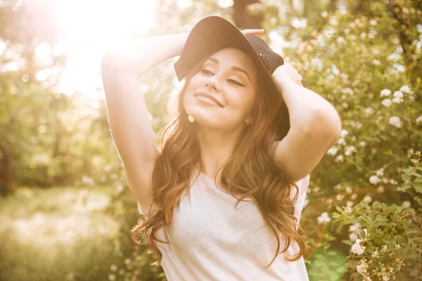 Glücklich schöne junge Frau lächelt und träumt im Garten — Stockfoto