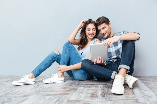 Cuplu folosind tableta așezat pe podea acasă — Fotografie, imagine de stoc