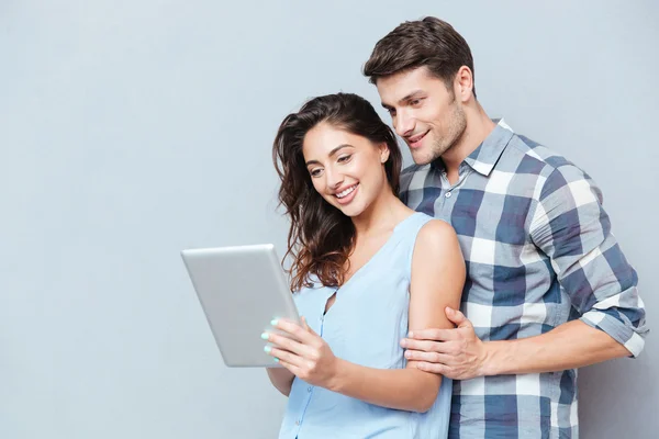 Casal de pé em casa e usando tablet digital — Fotografia de Stock