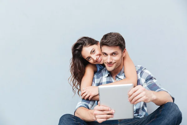 Casal sentado em casa e usando tablet digital — Fotografia de Stock