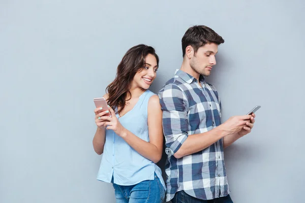 Girlfriend watching his boyfriend texting on the phone — Stock Photo, Image