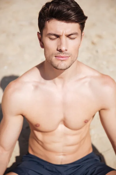 Uomo con gli occhi chiusi meditando sulla spiaggia — Foto Stock