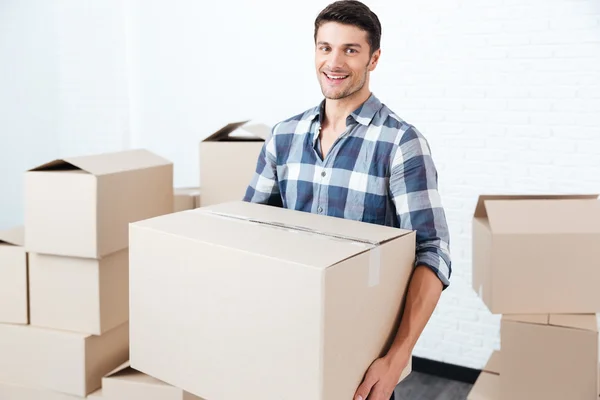 Uśmiechający się zadowolony człowieka, pudła kartonowe, w nowe mieszkanie — Zdjęcie stockowe
