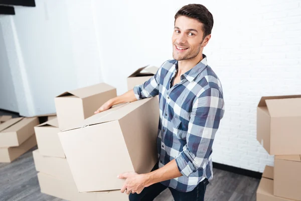 Lycklig man flyttar in och bära kartong lådor — Stockfoto