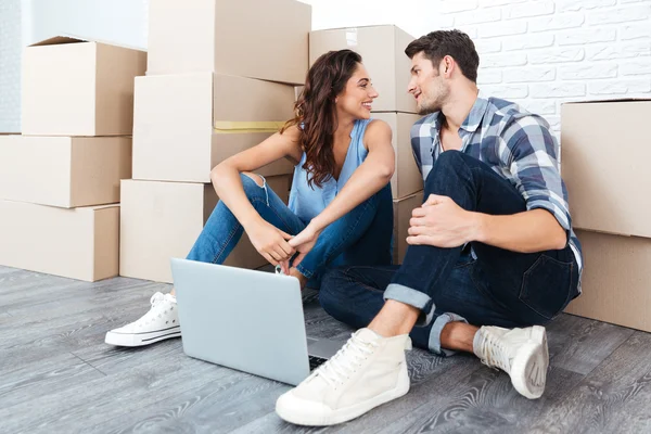 Ungt par sitter på golvet i deras nya lägenhet — Stockfoto